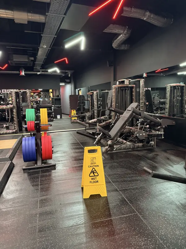 Gym machines and plate rack on a freshly mopped floor