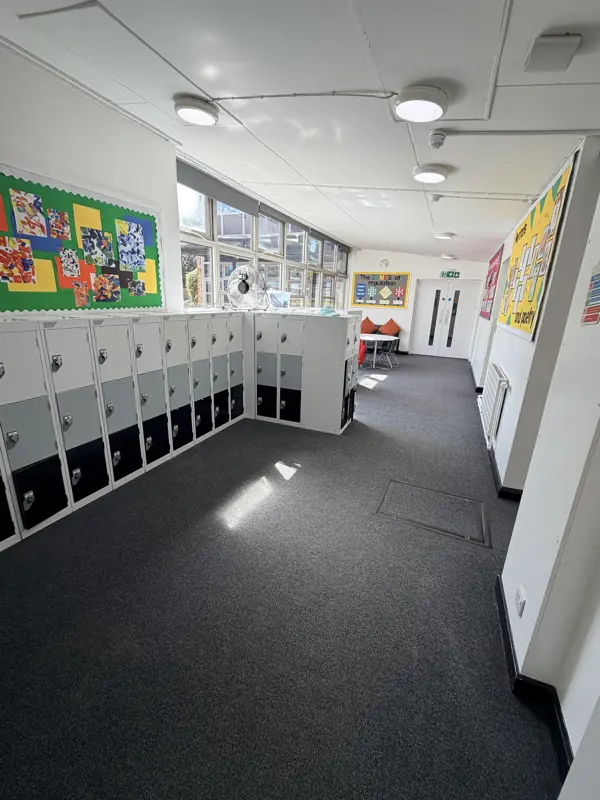 School cloakroom with lockers and a clean grey carpet