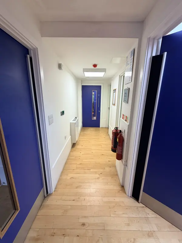 Narrow school corridor with a clean wooden floor